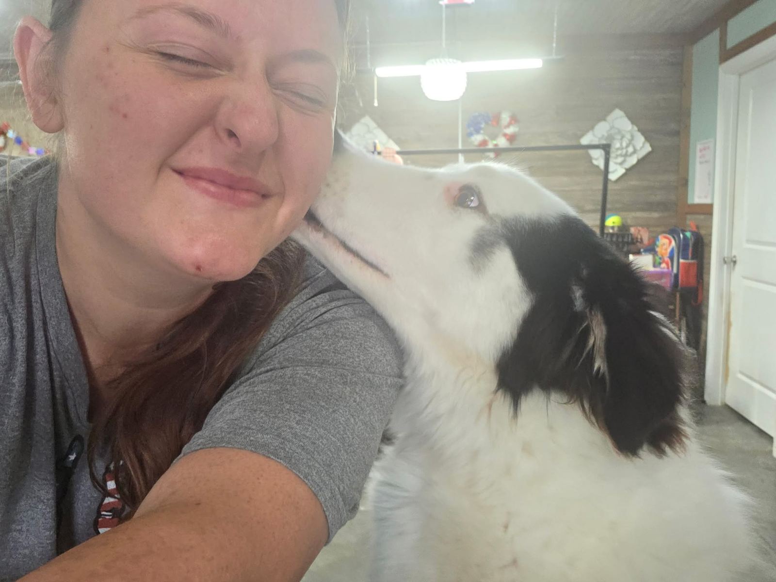 Southern Paws Spa team member sharing affection with a black and white dog